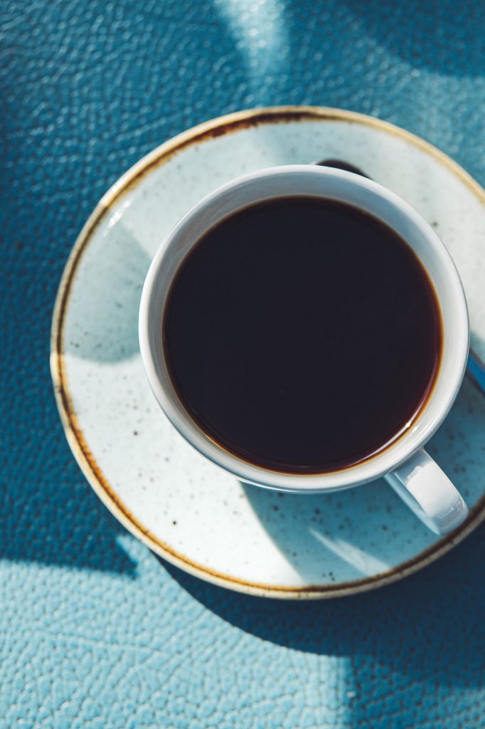 Tasse schwarzer Kaffee auf hellem Teller im Grande Beach Café Scharbeutz