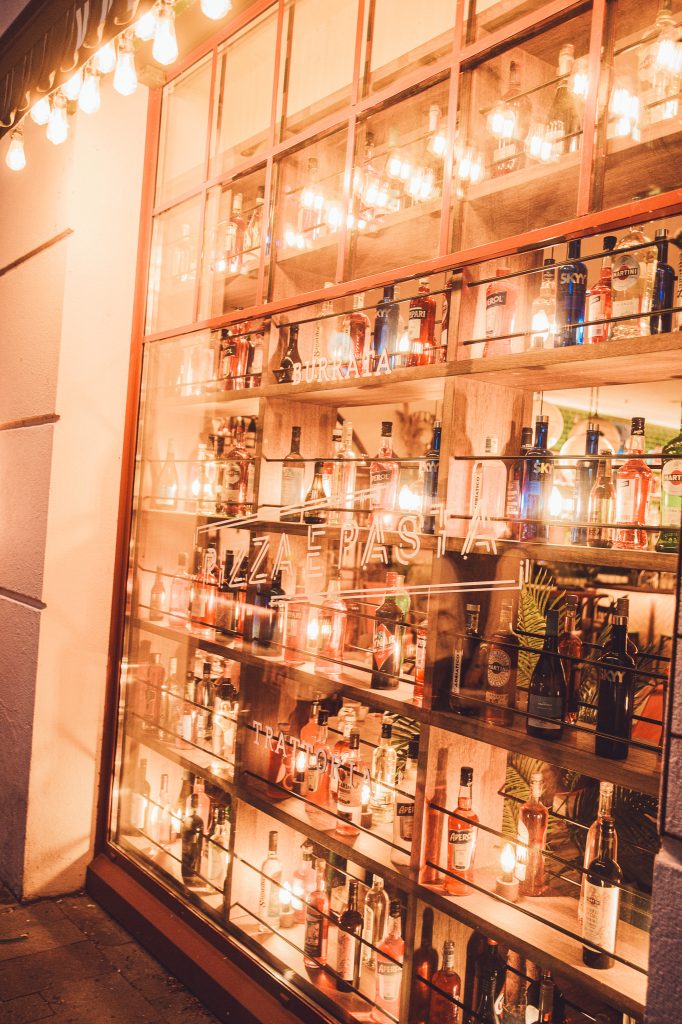 Beleuchtetes Schaufenster eines italienischen Restaurants mit Spirituosen in Lyon