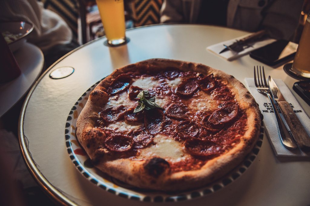 Salami-Pizza mit Mozzarella und Basilikum in einem Restaurant in Lyon