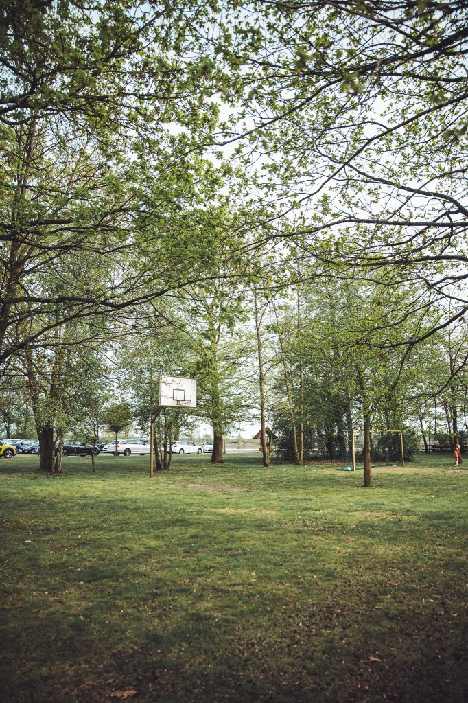Wiese mit Bäumen, Basketballkorb und Spielbereich am Spargel und Beerenhof Heuer bei Hannover