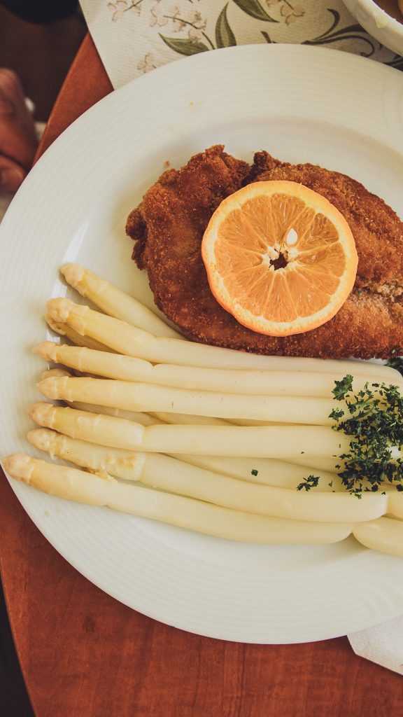 Klassischer Teller mit weißem Spargel und paniertem Schnitzel beim Spargel und Beerenhof Heuer