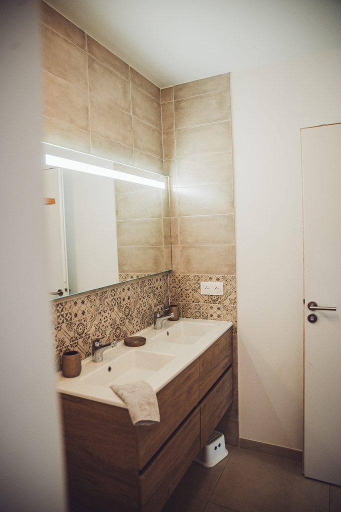 Badezimmer mit Doppelwaschbecken, Holzunterschrank, großem Spiegel und Kinderhocker bei Toulon
