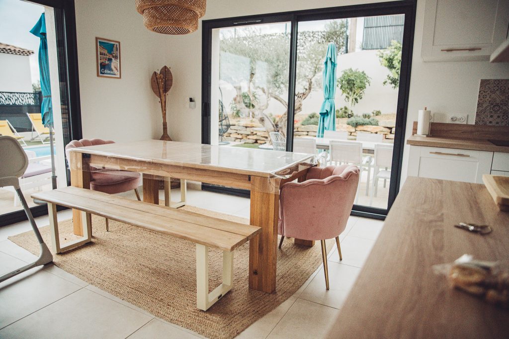 Heller Essbereich mit Holztisch, Sitzbank und Blick auf Terrasse und Pool in Toulon