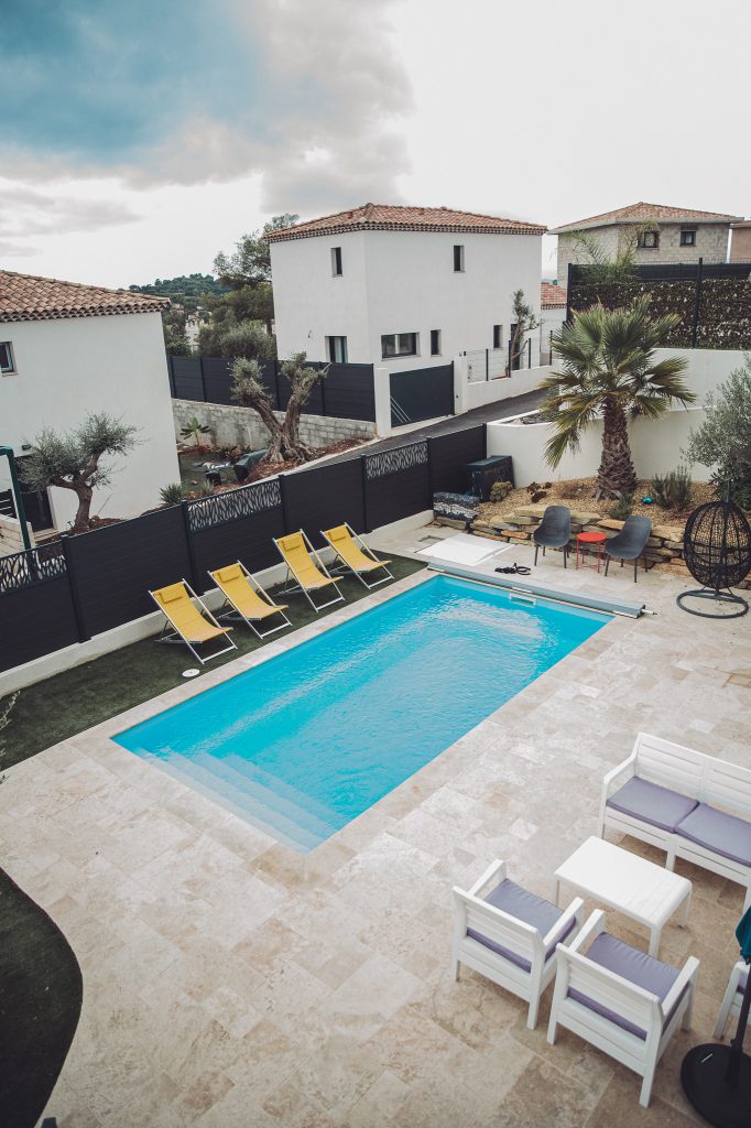 Pool mit gelben Sonnenliegen und großer Terrasse an einer Ferienwohnung bei Toulon