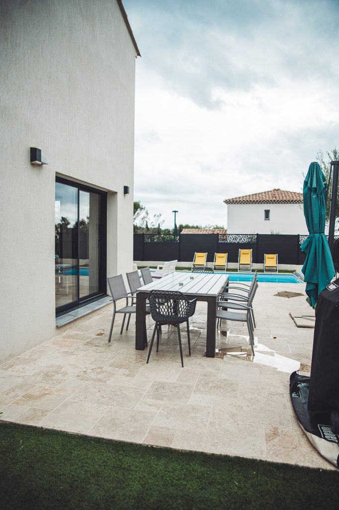 Große Terrasse mit Esstisch, Stühlen und Pool an einer Ferienwohnung in Toulon