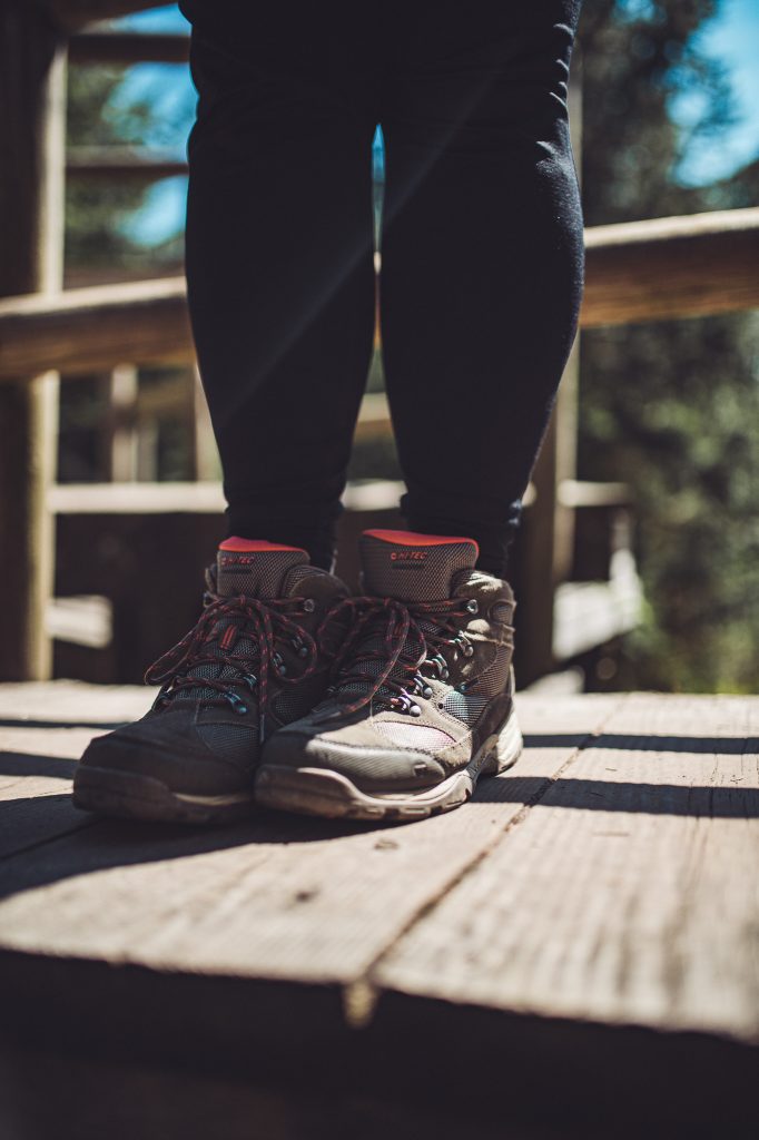 Wanderstiefel auf Holzplanken des Lotharpfads im Schwarzwald